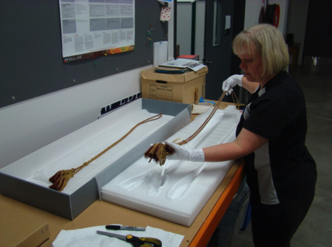 Registrar Claire Orbell packing the cord and tassels from the colours Registrar Claire Orbell packing the cord and tassels from the colours